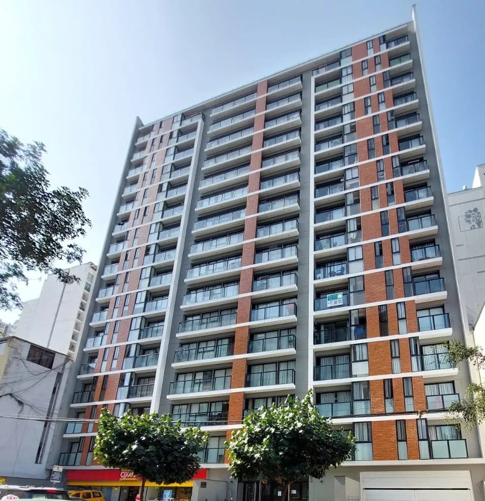 Fachada de un edificio de departamentos moderno con balcones de vidrio